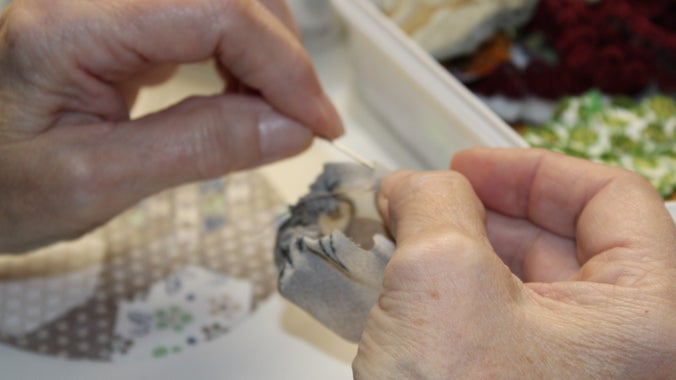 A close-up of one of the group working on the quilt.